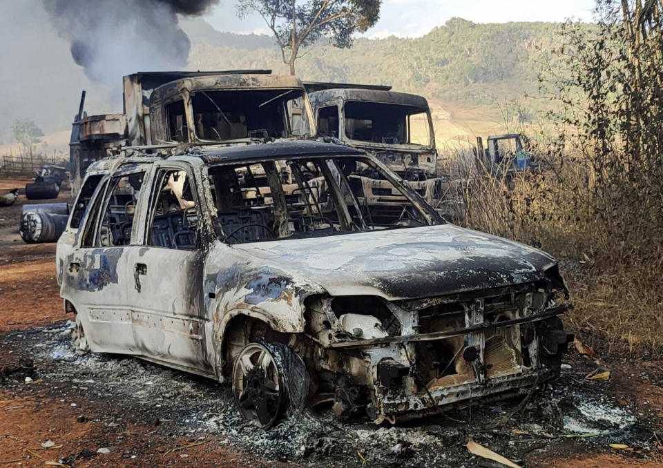 In this photo provided by the Karenni Nationalities Defense Force (KNDF), vehicles smolder in Hpruso township, Kayah state, Myanmar, Friday, Dec. 24, 2021. Myanmar government troops rounded up villagers, some believed to be women and children, fatally shot more than 30 and set the bodies on fire, a witness and other reports said Saturday. (KNDF via AP)