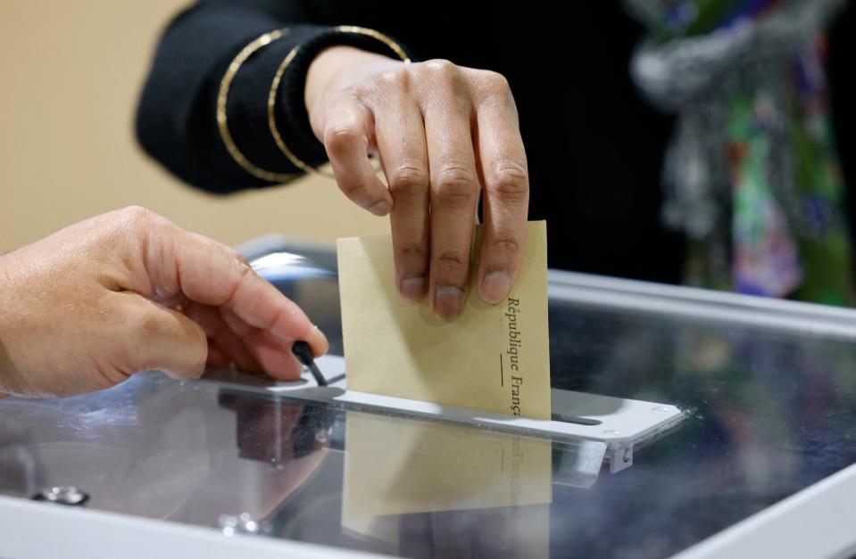 Une électrice glisse son bulletin dans une urne du Touquet pour le premier tour des législatives, le 12 juin 2022 - Ludovic MARIN - AFP