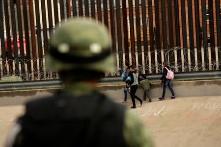 National Guard soldier observes migrants after crossing illegally into El Paso, Texas, U.S. to turn themselves in to U.S. Border Patrol agents to ask for asylum, as seen from Ciudad Juarez