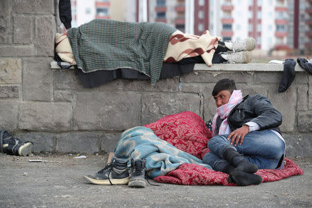 Afghan migrants rest outside a bus terminal as they struggle to find buses to take them to western Turkish cities after crossing the Turkey-Iran border in Agri, eastern Turkey, April 11, 2018. Picture taken April 11, 2018. REUTERS/Umit Bektas