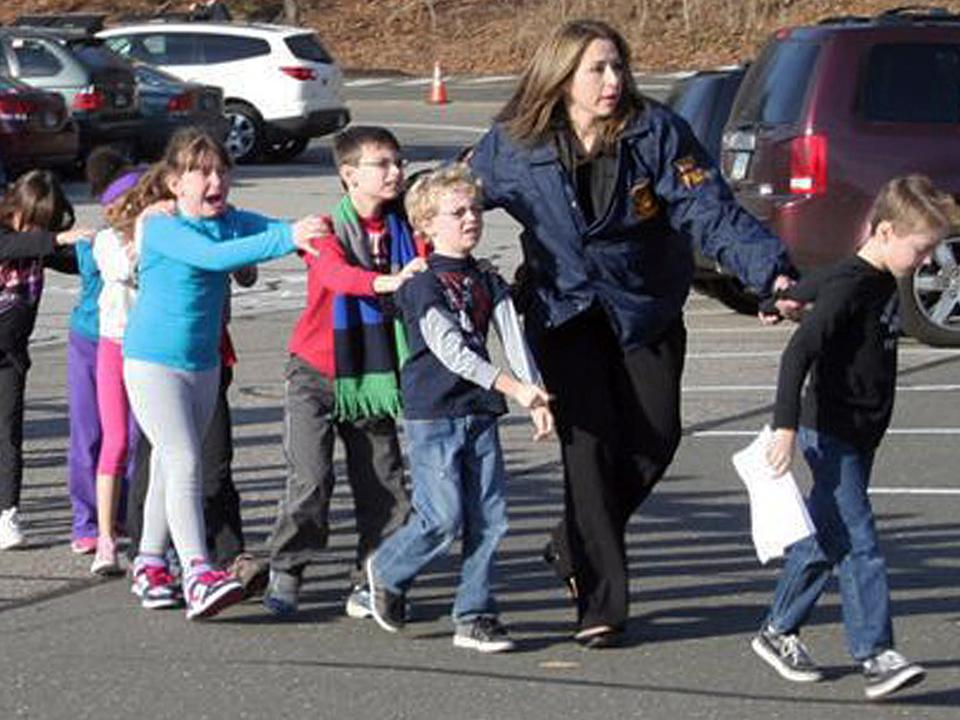 A police officer leads children from Sandy Hook Elementary.