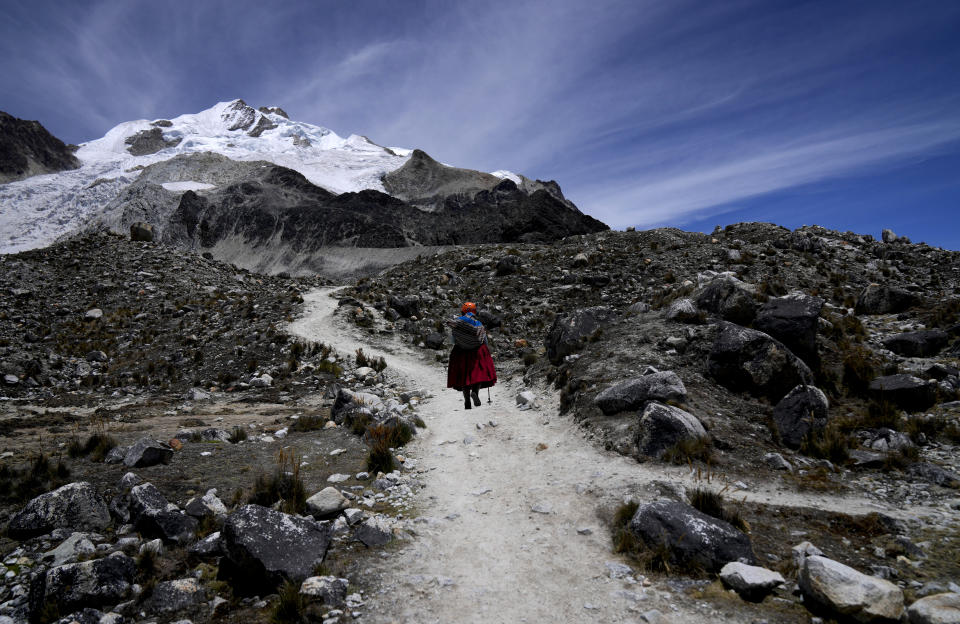 Cholita climber Suibel Gonzales walks towards the Huayna Potosi mountain snow-capped peak, near El Alto, Bolivia, Sunday, Nov. 5, 2023. Dressed up on colorful, multilayered skirts, Gonzales is part of a group of 20 Indigenous Bolivian women who have been climbing the Andes peaks for the past eight years, working as guides for tourists. But as the glaciers in the South America country continue to retreat amid an increase in the average global temperature, they are worried about the future of their jobs. (AP Photo/Juan Karita)