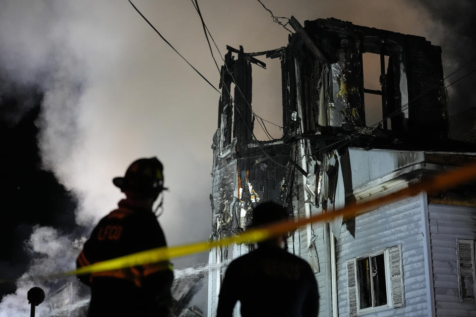 Firefighters work at the scene where two police officers were injured while responding to reported standoff in East Lansdowne, Pa., on Wednesday, Feb. 7, 2024. (AP Photo/Matt Rourke)