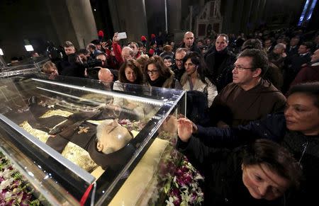 Faithful surround the exhumed body of the mystic saint Padre Pio in the Catholic church of San Lorenzo fuori le Mura in Rome, February 3, 2016. REUTERS/Yara Nardi