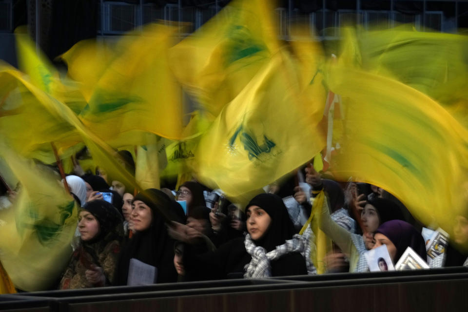 Hezbollah supporters wave their group flags as they listen to a speech of Hezbollah leader Sayyed Hassan Nasrallah, via a video link, during a rally marking Hezbollah Martyr's Day, Lebanon, Friday, Nov. 11, 2022. Nasrallah said his group wants a new Lebanese president that will not "betray" the Iran-backed faction in the future adding that the United States is doing all it can strangle the group. (AP Photo/Bilal Hussein)