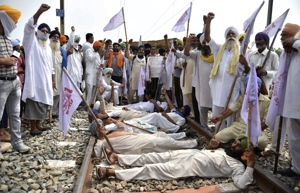 Farmers shout slogans as they block a railway track protesting against the new farm bills, at Devi Dass Pura village, about 20 kilometers from Amritsar, India. Farmers across the state have threatened to stop train services as they demanded a rollback in three new farm bills of the central government, stating that these are against the interests of farmers. (AP Photo/Prabhjot Gill)