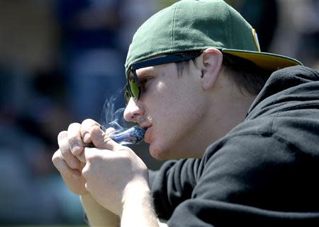 A man smokes marijuana from a pipe during the 4/20 Rally at the Civic Center in Denver, Colorado, April 20, 2014. REUTERS/Mark Leffingwell