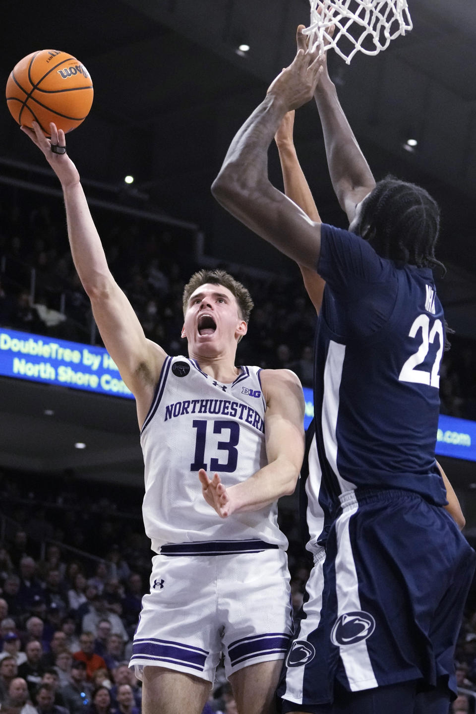 Northwestern guard Brooks Barnhizer, left, drives to the basket against Penn State forward Qudus Wahab, right, during the second half of an NCAA college basketball game in Evanston, Ill., Sunday, Feb. 11, 2024. (AP Photo/Nam Y. Huh)