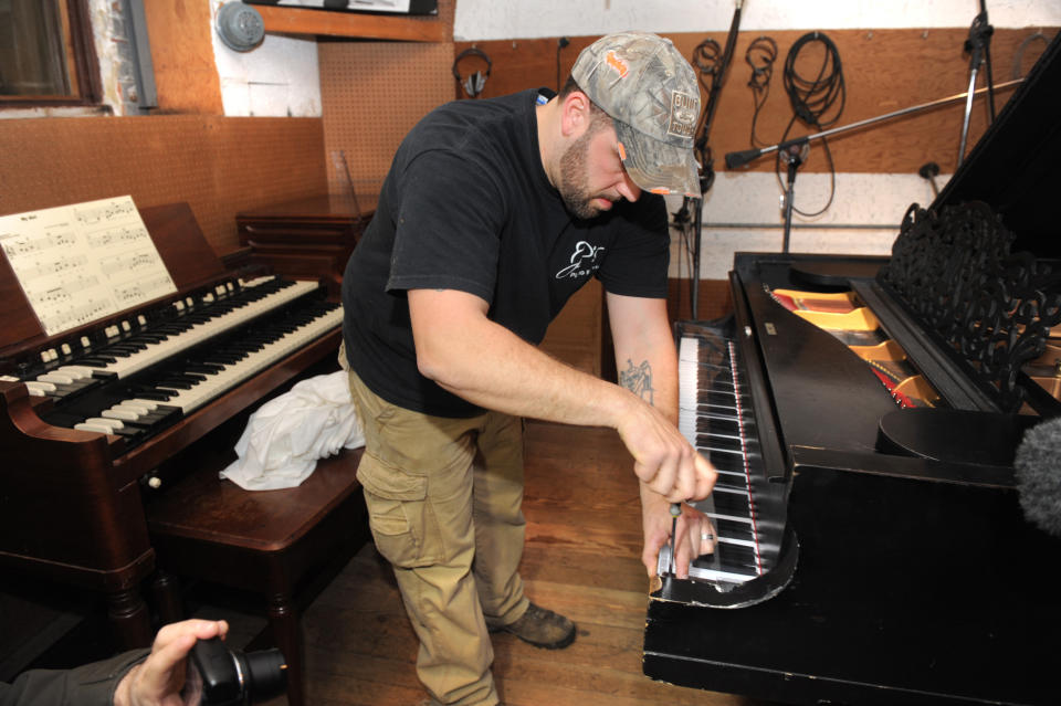 Billy Brasile, of JP's Piano Movers, Oxford, Michigan, installs a keyboard cover at Detroit's Motown Museum where the museum's prized Steinway grand piano was moved back into Studio A on Monday, April 1, 2013. The 1877 Steinway grand piano used by Motown greats during the label's 1960s heyday, and restored thanks to Paul McCartney, is back home in Detroit. (AP Photo/The Detroit News, Max Ortiz)