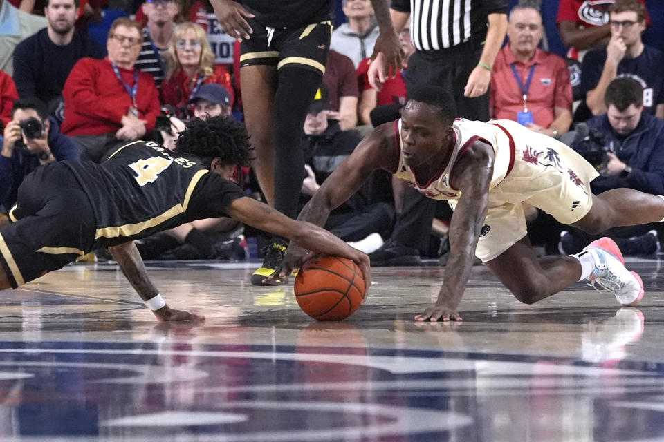 UAB guard Eric Gaines (4) and Florida Atlantic guard Johnell Davis go after a loose ball during the first half of an NCAA college basketball game, Sunday, Jan. 14, 2024, in Boca Raton, Fla. (AP Photo/Marta Lavandier)