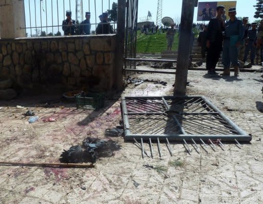 Afghan policemen inspect the site of a suicide attack in Maymana, the capital of Faryab province, on Wednesday. The suicide bomber attacked foreign military forces, killing at least 12 people including three international troops, officials said