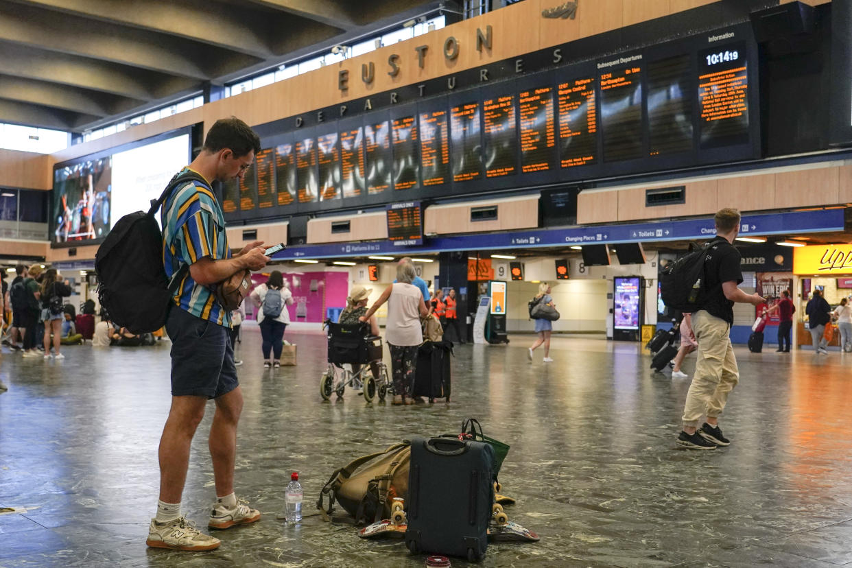 Passengers await their trains to be announced, at a quiet Euston station, in London, Tuesday, June 21, 2022. Tens of thousands of railway workers walked off the job in Britain on Tuesday, bringing the train network to a crawl in the country’s biggest transit strike for three decades. (AP Photo/Alberto Pezzali)