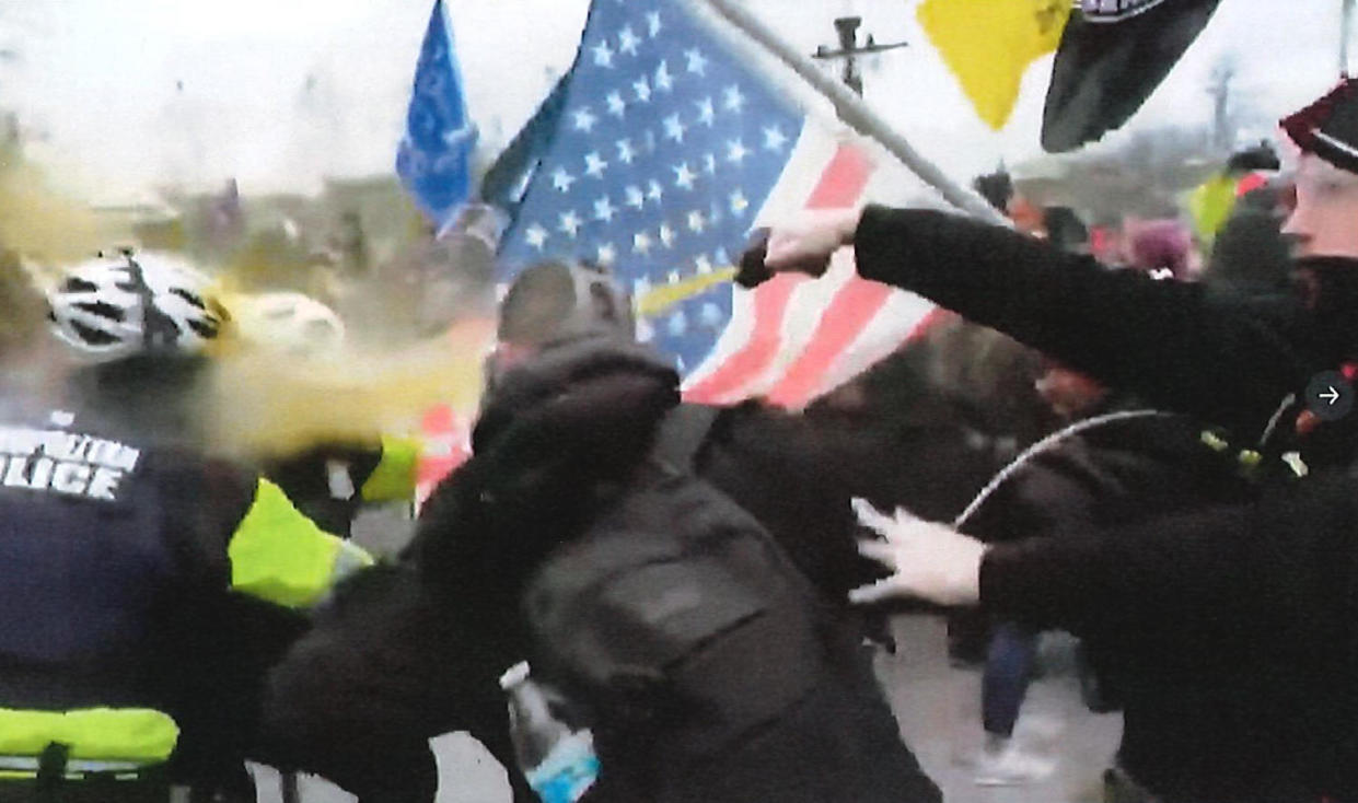 Andrew Taake, right, seen attacking officers with chemical spray on Jan. 6.  (US Attorney's Office for the District of Columbia)