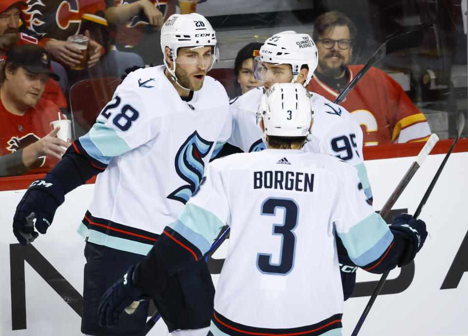 Seattle Kraken defenseman Carson Soucy, left, celebrates his goal with teammates during the first period of an NHL hockey game against the Calgary Flames, Tuesday, Nov. 1, 2022 in Calgary, Alberta. (Jeff McIntosh/The Canadian Press via AP)