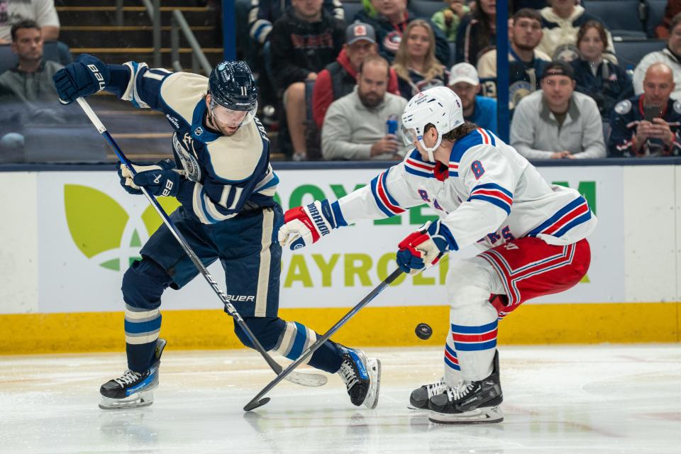 Oct 14, 2023; Columbus, Ohio, United States;
Columbus Blue Jackets center Adam Fantilli (11) fights for the puck against New York Rangers defenseman Jacob Trouba (8) during their game on Saturday, Oct. 14, 2023 at Nationwide Arena.