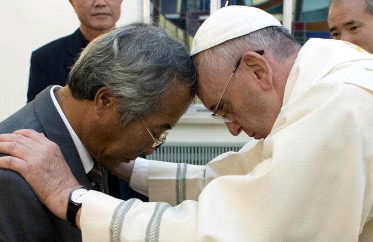 Pope Francis (R) baptises Lee Ho-Jin, 56, father of one of hundreds of high school students killed in South Korea's Sewol ferry disaster in April, in Seoul, on August 17, 2014