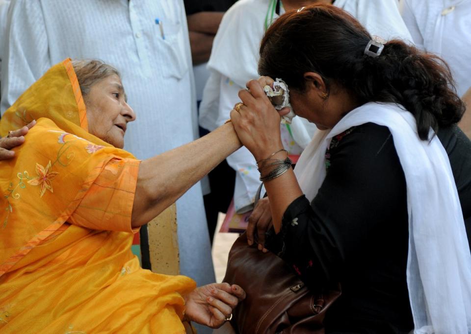 Widow Zakia Jafri (L) comforts grieving mother Rupa Modi outside a court in Ahmedabad on 26 December, 2013, following a judgement over the riots in favour of then-Gujarat chief minister Narendra Modi (Getty Images)