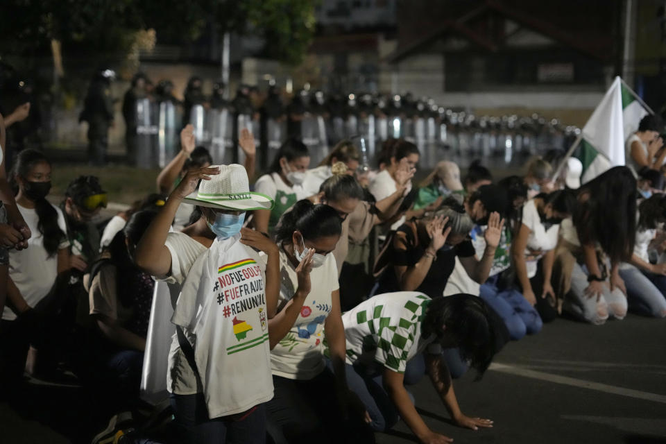 Seguidores del líder opositor y gobernador de Santa Cruz Luis Fernando Camacho se arrodillan durante una protesta en una barricada en Santa Cruz, Bolivia, el 3 de enero de 2023. (AP Foto/Juan Karita)