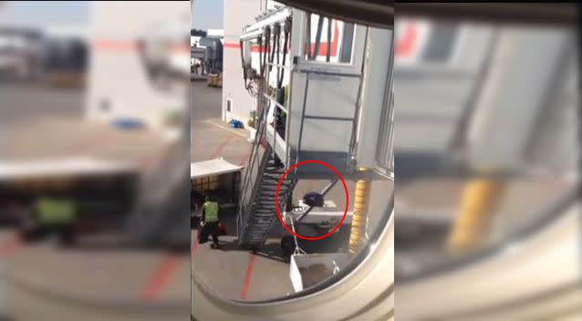 A baggage handler can be seen dropping items of luggage more than six metres into a bin. Photo: YouTube.