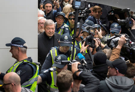 Vatican Treasurer Cardinal George Pell is surrounded by Australian police and members of the media as he leaves the Melbourne Magistrates Court in Australia, July 26, 2017. REUTERS/Mark Dadswell/Files