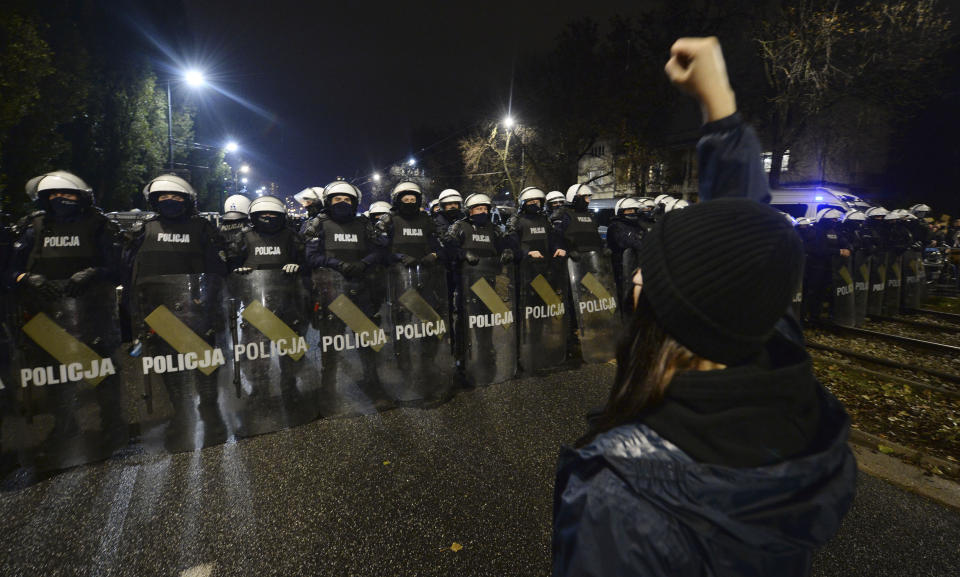 Riot police line up as a crowd gathers outside the house of Poland's ruling conservative party leader Jaroslaw Kaczynski in Warsaw, Poland, Friday, Oct. 23, 2020. Protesters vented anger for a second day across Poland over a court ruling that declared abortions of fetuses with congenital defects unconstitutional. The hundreds of protesters who gathered in many cities defied a COVID-19-related ban on gatherings that was imposed nationwide on Friday. (AP Photo/Czarek Sokolowski)
