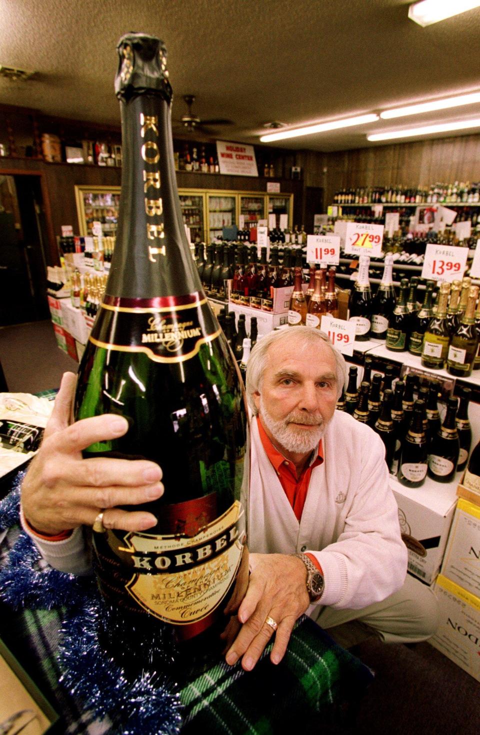 Fred Gatewood, owner of Holiday Wine and Spirits in Franklin, poses with balthazar, a 44-pound bottle of champage, Dec. 6, 1999. This Korbel Champagne of the Millennium collector's bottle holds 85, five oz. glasses and 780,000,000 bubbles. The $2,000 bottle will be auctioned at the Heritage Foundation's Millennium Ball. The bottle is one of 2,000 made.