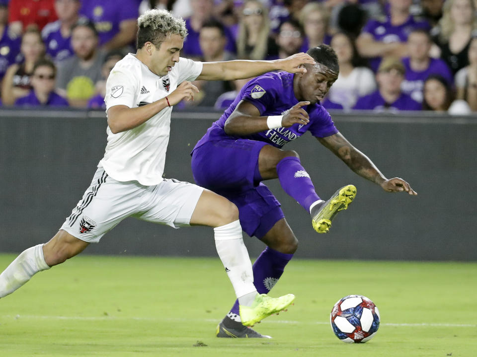 D.C. United's Lucas Rodriguez, left, and Orlando City's Sebas Mendez, right, battle for possession of the ball during the second half of an MLS soccer match, Sunday, March 31, 2019, in Orlando, Fla. (AP Photo/John Raoux)