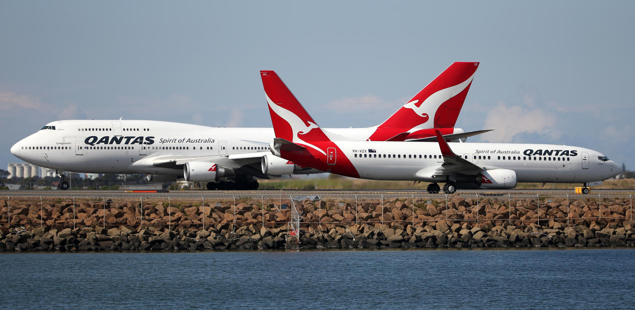 FILE - In this Aug. 20, 2015 file photo, two Qantas planes taxi on the runway at Sydney Airport in Sydney, Australia. Qantas Airways Ltd. posted a record full-year profit of 1.53 billion Australian dollars ($1.1 billion) on Wednesday, Aug. 24, 2016, after undergoing a cost-saving restructuring amid steep losses just two years ago. (AP Photo/Rick Rycroft)