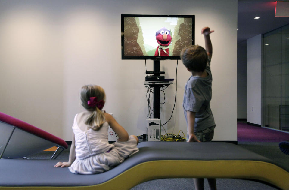 In this Sept. 5, 2012, photo, from left, Zoe Shyba, 3, left, and Aidan Lain, 7, play "Kinect Sesame Street TV" at the Sesame Street Workshop in New York. "Kinect Sesame Street TV", launching Tuesday, Sept. 18, 2012, uses Kinect, a motion and voice-sensing controller created by Microsoft, to give Elmo, Big Bird and the rest of the Sesame Street crew a chance to have a real two-way conversation with their pint-sized audience. The effort represents the next step in the evolution of television, adding an interactive element to what's still largely a passive, lean-back experience. (AP Photo/Mark Lennihan)