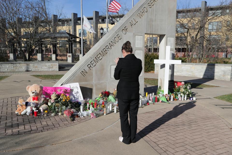 Jodi, who didn't want to giver her last name, takes a photo of a memorial at Veterans Park in Waukesha on Tuesday, Nov. 23, 2021, near where a person plowed their SUV through the Waukesha Christmas Parade on Sunday leaving five dead and more than 40 injured authorities say.