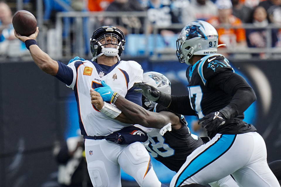 Denver Broncos quarterback Russell Wilson passes under pressure during the first half of an NFL football game between the Carolina Panthers and the Denver Broncos on Sunday, Nov. 27, 2022, in Charlotte, N.C. (AP Photo/Rusty Jones)