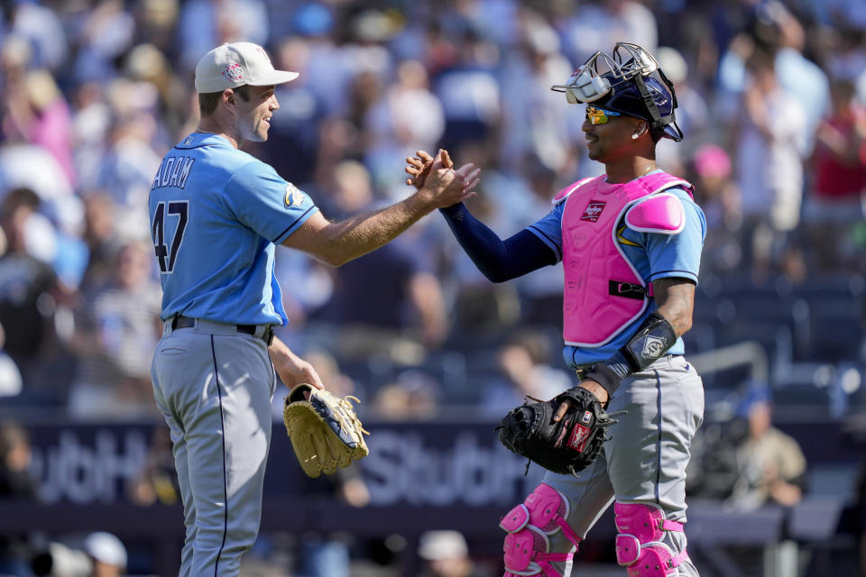 Tampa Bay Rays relief pitcher Jason Adam (47) celebrates with catcher Christian Bethancourt (14) after closing the ninth inning of a baseball game against the New York Yankees, Sunday, May 14, 2023, in New York. (AP Photo/John Minchillo)