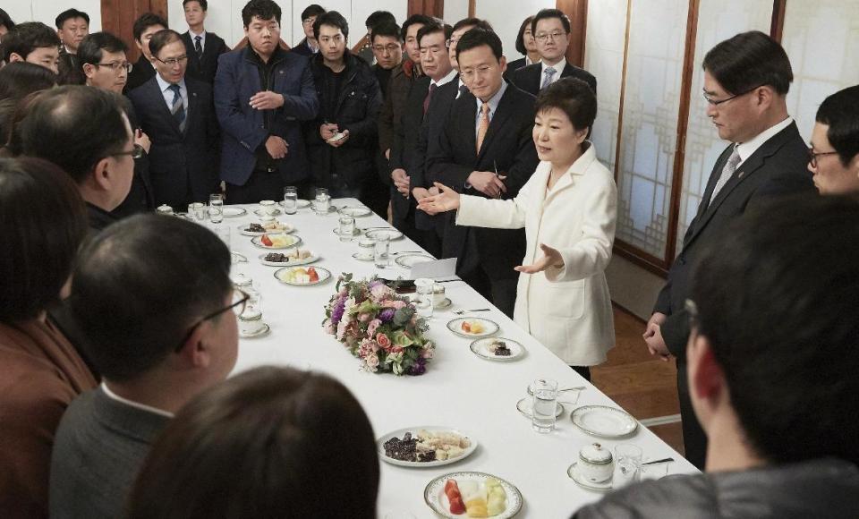 In this photo provided by the South Korean Presidential House, impeached South Korean President Park Geun-hye, third from right, speaks during a meeting with a selected group of reporters at the presidential house in Seoul, South Korea, Sunday, Jan. 1, 2017. Park vehemently rejected accusations Sunday that she conspired with a longtime friend to extort money and favors from companies, accusing her opponents of framing her. (The South Korean Presidential House via AP)
