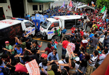 Protesters try to trash a police mobile patrol vehicle as they join various activist and Indigenous People's (IP) groups in a protest against the continuing presence of U.S. troops in the Philippines in front of the U.S. Embassy in metro Manila. REUTERS/Romeo Ranoco