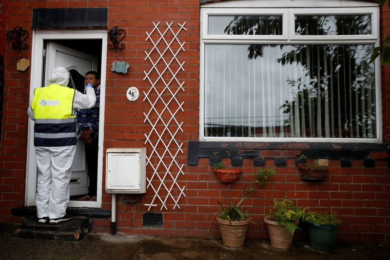 A member of the community swabbing team carries out a doorstep COVID-19 test following the outbreak of the coronavirus disease (COVID-19) in Chadderton, Britain