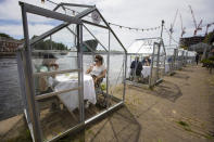 Customers seated in small glasshouses enjoy lunch at the Mediamatic restaurant in Amsterdam, Netherlands, Monday, June 1, 2020. The government took a major step to relax the coronavirus lockdown, with bars, restaurants, cinemas and museums reopening under strict conditions, abiding by government guidelines and respecting social distancing to help curb the spread of the COVID-19 coronavirus. (AP Photo/Peter Dejong)