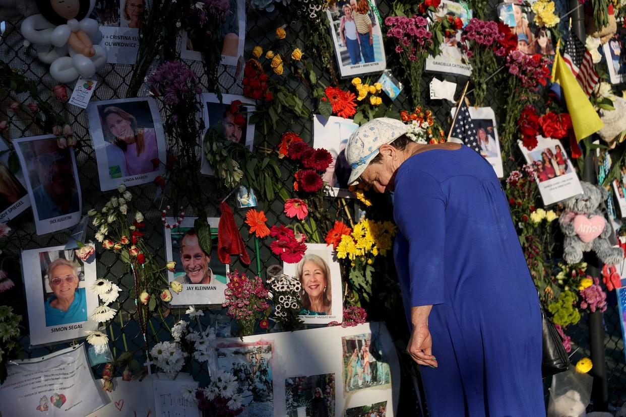 Valerie Flatto visits the memorial bearing photos of some of the victims of the partially collapsed Champlain Towers South condo building on July 15 in Surfside, Fla.