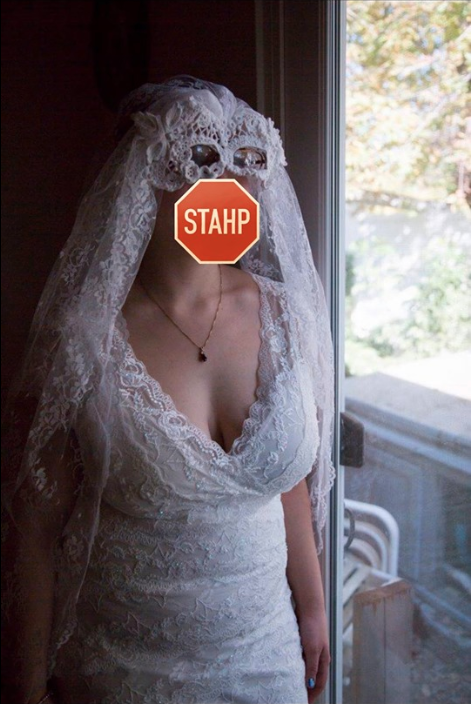 Bride wearing a mask and veil looking out the window on her wedding day