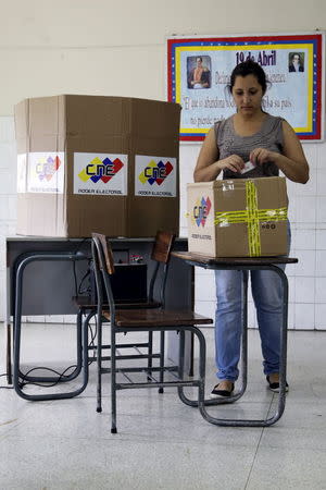 A woman folds up her marked ballot before casting it in a box during opposition coalition primaries for parliamentary election in Caracas May 17, 2015. REUTERS/Marco Bello