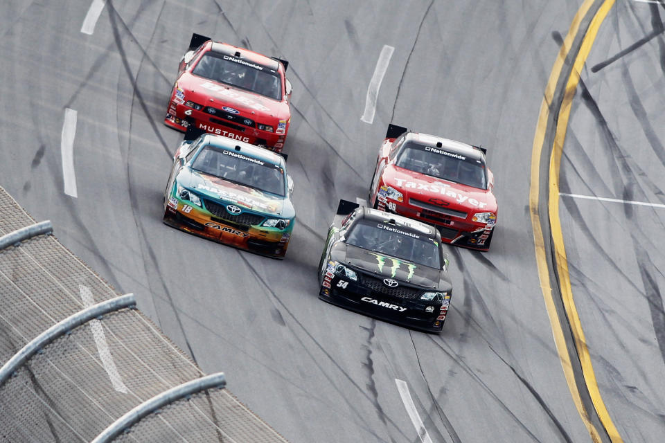 TALLADEGA, AL - MAY 05: Joey Logano, driver of the #18 GameStop Toyota, passes Kyle Busch, driver of the #54 Monster Energy Toyota, to take the lead and win the NASCAR Nationwide Series Aaron's 312 at Talladega Superspeedway on May 5, 2012 in Talladega, Alabama. (Photo by Todd Warshaw/Getty Images for NASCAR)