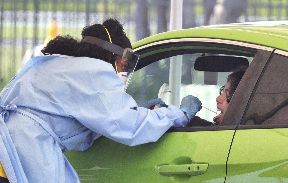 A patient gets swabbed during Covid-19 testing at Osceola Heritage Park in Kissimmee, Fla., Monday, July 13, 2020. Drive-thru testing at OHP continues through July 17, 9:00 a.m. to 2:00 p.m daily; appointments are not required. (Joe Burbank/Orlando Sentinel via AP)