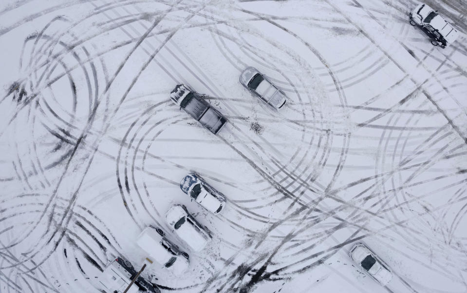 A tapestry of car tracks are created in the Canyon Rim Center parking lot following snow fall in the Salt Lake Valley, Utah., on Wednesday, Feb. 22, 2023. Brutal winter weather hammered the northern U.S. Wednesday with “whiteout” snow, dangerous wind gusts and bitter cold, shutting down roadways, closing schools and businesses and prompting dire warnings for people to stay home. (Francisco Kjolseth /The Salt Lake Tribune via AP)