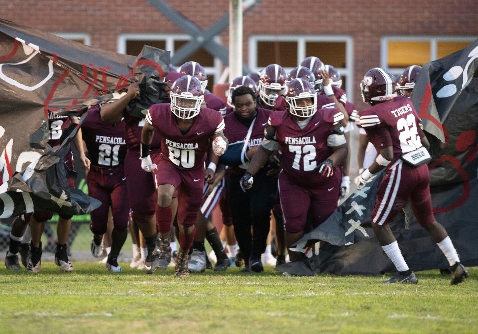 The Pensacola High football team storms the gridiron for the Tigers home opener against Washington High on Friday, Sept. 3, 2021.