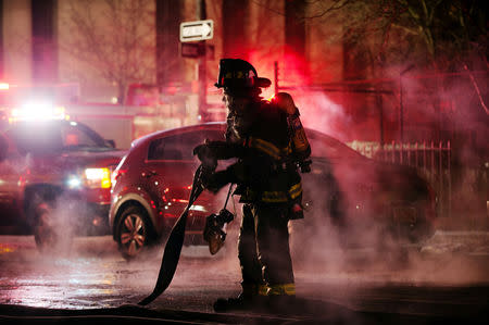 A member of the New York Fire Department (NYFD) works to extinguish a fire in frigid conditions in the Brooklyn Borough of New York, U.S., January 31, 2019. REUTERS/Lloyd Mitchell