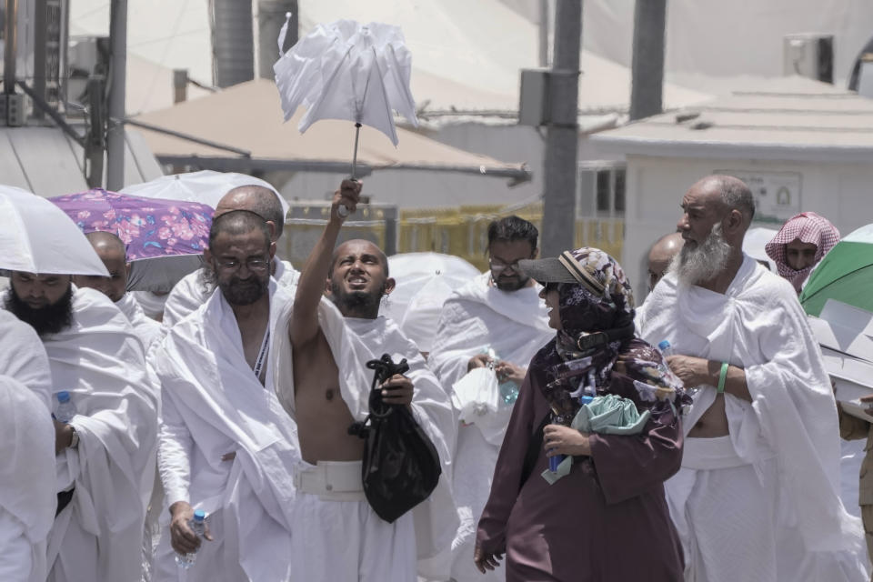 A Muslim pilgrim opens his umbrella at the Mina tent camp in Mecca, Saudi Arabia, during the annual Hajj pilgrimage, Monday, June 26, 2023. Muslim pilgrims are converging on Saudi Arabia's holy city of Mecca for the largest Hajj since the coronavirus pandemic severely curtailed access to one of Islam's five pillars. (AP Photo/Amr Nabil)