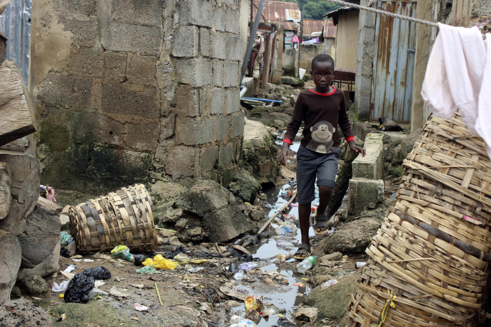 A boy walks past sewage around houses in Abuja, Nigeria, Friday, Sept. 3, 2021. Nigeria is seeing one of its worst cholera outbreaks in years, with more than 2,300 people dying from suspected cases as the West African nation struggles to deal with multiple disease outbreaks. This year’s outbreak which is associated with a higher case fatality rate than the previous four years is also worsened by what many consider to be a bigger priority for state governments: the COVID-19 pandemic. (AP Photo/Gbemiga Olamikan)