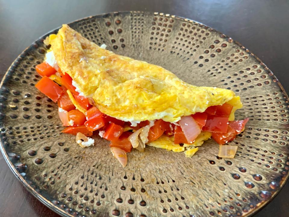 omelet with tomatoes on a brown plate