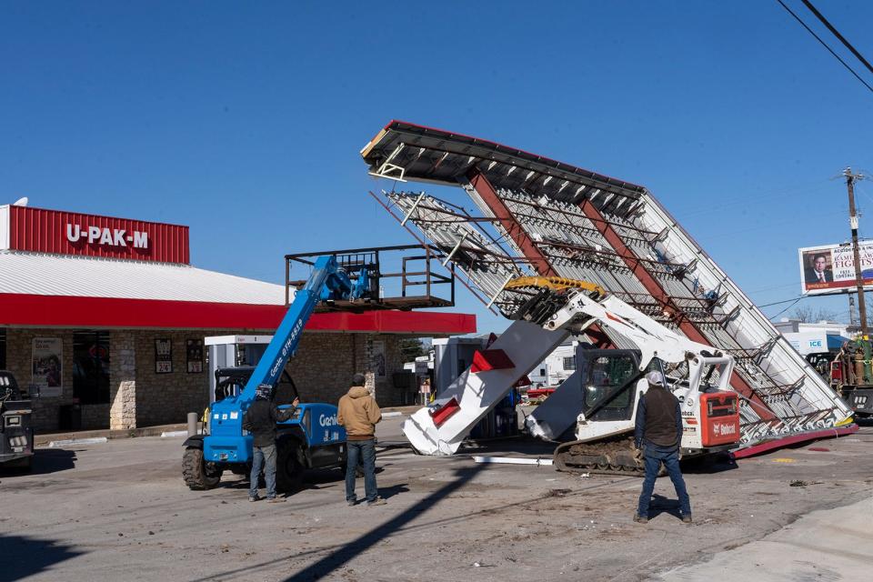 A crew Tuesday tackles the damage left by Monday night's high winds, removing a collapsed gas station canopy in South Austin.