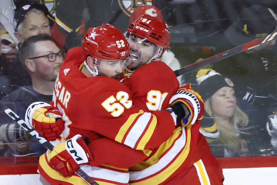 Calgary Flames' Nazem Kadri, right, celebrates his overtime goal against the Boston Bruins with MacKenzie Weegar during an NHL hockey game Thursday, Feb. 22, 2024, in Calgary, Alberta. (Larry MacDougal/The Canadian Press via AP)