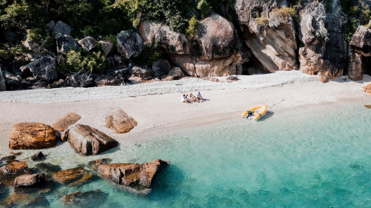 Family sitting on a coral beach